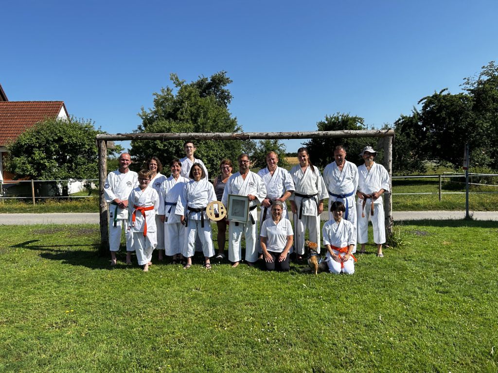Ein Gruppenfoto der Teilnehmer\*innen auf der Wiese